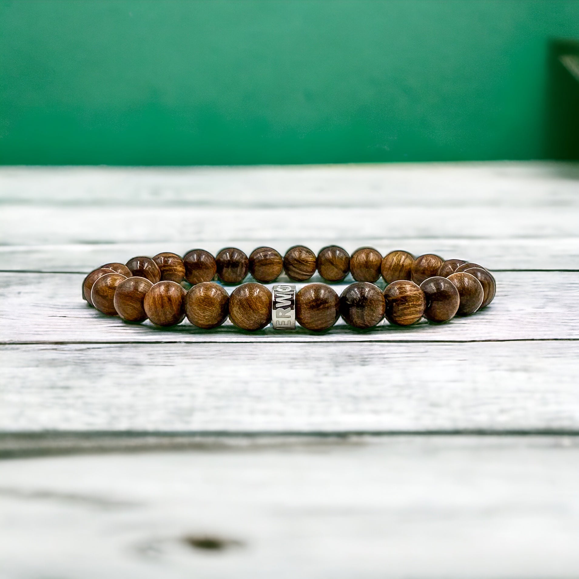 Beaded Bracelet handmade with Black Walnut Wood beads on white wood countertop with green walls 