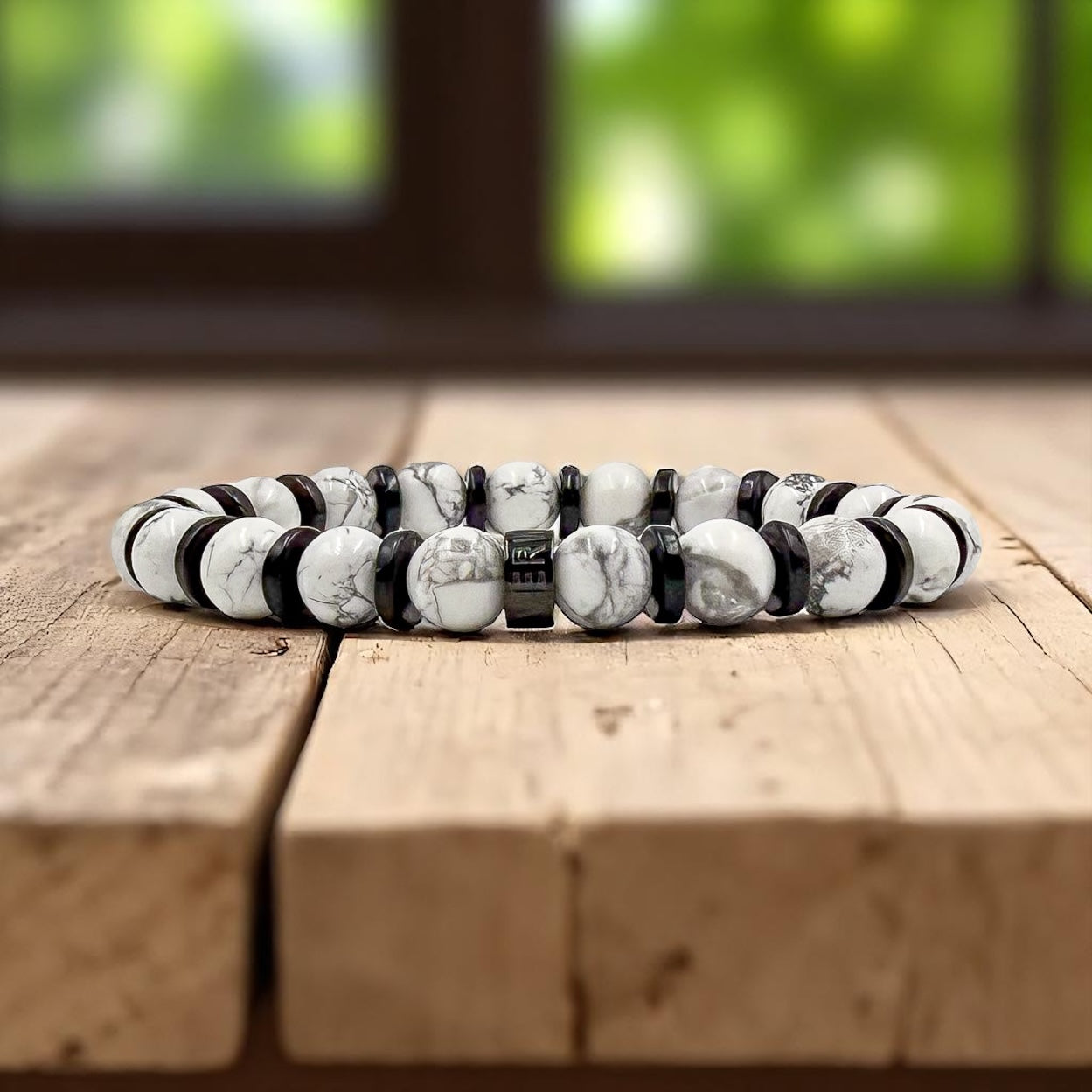 Pulse men’s beaded bracelet made with white howlite and blackwood beads on wood tabletop